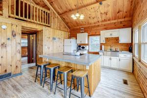 una cucina con bancone e sgabelli in una cabina di Modern Log Chalet - Upper Level a Montgomery