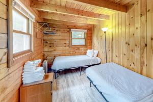 a room with two beds in a wooden cabin at Modern Log Chalet - Upper Level in Montgomery