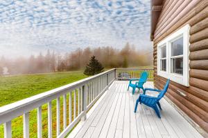 dos sillas azules sentadas en una terraza en una casa en Modern Log Chalet - Upper Level, en Montgomery