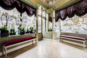 a waiting room with benches and potted plants at Hotel du Petit Moulin in Paris