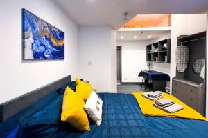 ein Schlafzimmer mit einem blauen Bett und gelben Kissen in der Unterkunft Apartment in city centre Leicester in Leicester