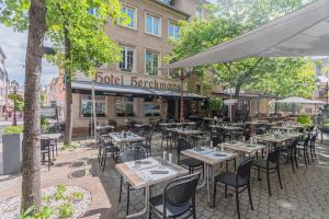 a restaurant with tables and chairs in front of a building at Hotel Herckmans in Ettelbruck