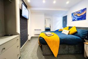 ein Schlafzimmer mit einem Bett mit einer gelben Decke darauf in der Unterkunft Apartment in city centre Leicester in Leicester