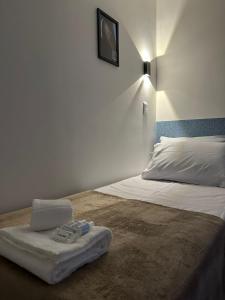 1 dormitorio con cama con almohada y reloj en la pared en Audaar Tech Suítes - Aeroporto de Congonhas en São Paulo