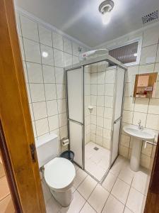 a bathroom with a shower and a toilet and a sink at Apartamento Praia Grande Ubatuba 2 vagas garagem Internet WiFi in Ubatuba
