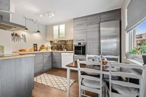 a kitchen with stainless steel appliances and a table at Cozy 130sqm house right above the city center. in Tromsø
