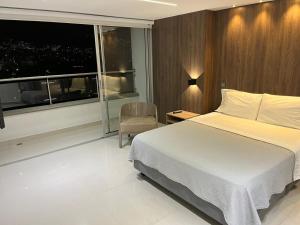 1 dormitorio con cama y ventana grande en medellin - conquistadores 17, en Medellín