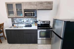 uma cozinha com um frigorífico de aço inoxidável e micro-ondas em Stay Here! 10 MIN FROM BEACH! 2 bedroom house em Puerto Peñasco