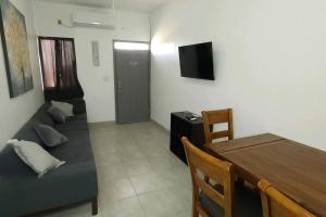 a living room with a couch and a table and a television at Stay Here! 10 MIN FROM BEACH! 2 bedroom house in Puerto Peñasco