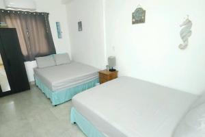 a room with two beds and a couch in it at Stay Here! 10 MIN FROM BEACH! 2 bedroom house in Puerto Peñasco