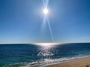 a sun shining over the ocean on a beach at Stay Here! 10 MIN FROM BEACH! 2 bedroom house in Puerto Peñasco