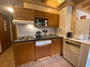 a small kitchen with wooden cabinets and a sink at Appartement Samoëns, 3 pièces, 6 personnes - FR-1-624-12 in Samoëns