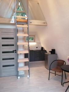 una escalera en un loft reconvertido con mesa y sillas en Rose Valley Cottage en Ieriķi