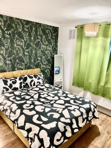 a bedroom with a bed with a black and white comforter at Private double room in the center of london in London