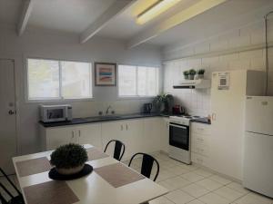 a kitchen with a table and a white refrigerator at Three Palms Apartments Unit 4 in Esperance