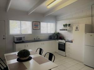 una cucina con un tavolo e un frigorifero bianco di Three Palms Apartments Unit 4 a Esperance