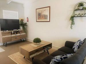- un salon avec un canapé et une télévision dans l'établissement Three Palms Apartments Unit 4, à Esperance