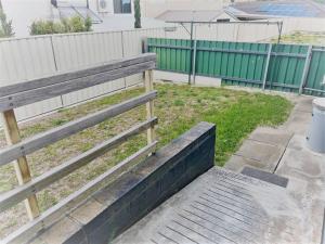 una panca di legno seduta accanto a una recinzione di Three Palms Apartments Unit 4 a Esperance