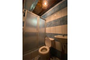 een badkamer met een douche, een toilet en een wastafel bij Rumipaxi Lodge in Latacunga