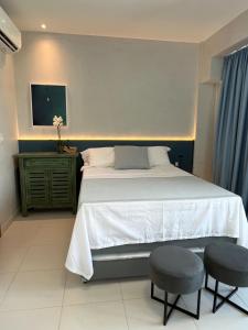 um quarto com uma cama grande e 2 bancos em Mana Beach Ohana 208 em Ipojuca