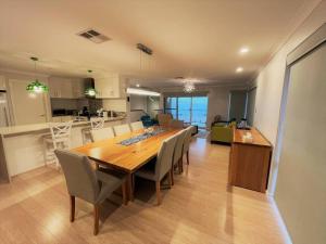 a dining room and kitchen with a table and chairs at West Beach House in Esperance