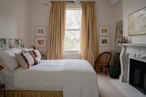 1 dormitorio con 1 cama, chimenea y ventana en Moss Manor, en Moss Vale