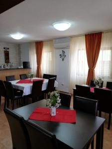 un restaurant avec des tables, des chaises et des serviettes rouges dans l'établissement Casa Carp Calarasi, à Călăraşi