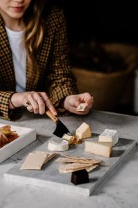 une femme qui coupe du fromage sur une table avec un couteau dans l'établissement Moss Manor, à Moss Vale
