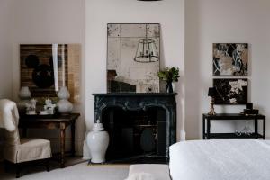 a bedroom with a black fireplace and a chair at Moss Manor in Moss Vale