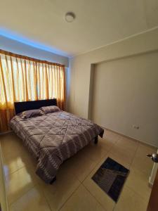 a bedroom with a bed and a large window at Departamento céntrico Huancayo in Huancayo