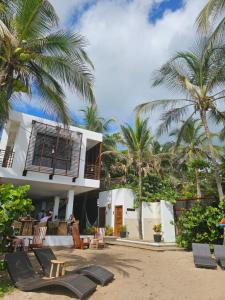 a house on the beach with palm trees at Makao Beach Hotel in Palomino