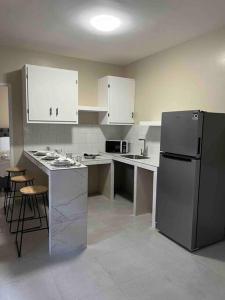 a kitchen with white cabinets and a stainless steel refrigerator at Suites González, Suite 2 in Ciudad Juárez