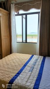 a bedroom with a bed with a view of the ocean at Quan Lan Nam Phong Hotel in Quan Lạn
