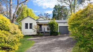 a white house with a garage at Scenic Cottage in Katoomba