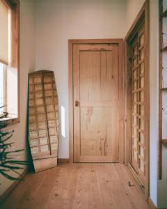 an empty room with a wooden door and a surfboard at guesthouse by good neighbor in Baltimore