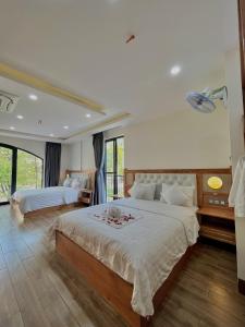 een grote slaapkamer met twee bedden en een groot raam bij SK BOUTIQUE HOTEL in Phu Quoc