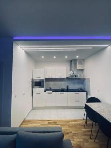 une cuisine avec des placards blancs et un plafond bleu dans l'établissement NS LUX STAN SOMBOR-No IMIGRANTS, à Sombor