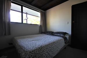 a bedroom with a bed with a black and white comforter at 43b Conical Hill Road in Hanmer Springs