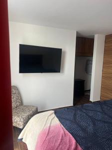 1 dormitorio con 1 cama y TV en la pared en Residencia comoda, en Santa María Coronanco