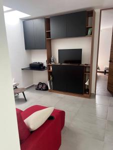 a living room with a red couch and a flat screen tv at Residencia comoda in Santa María Coronanco