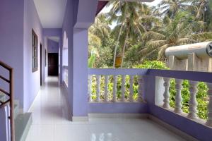 a hallway with blue walls and a balcony with palm trees at Ps Guest House Near Calangute Beach in Calangute