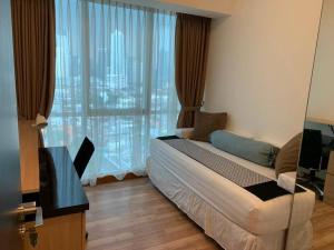 ein Schlafzimmer mit einem Bett und einem großen Fenster in der Unterkunft 2BR for Business Traveller at Sky Garden in Jakarta