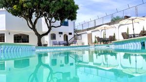 una piscina con sedie e un albero accanto a un edificio di Apartamento con hermosa vista a Manta