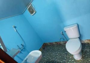 uma casa de banho com um WC e uma parede azul em Inthanon Lao-Ju House em Chom Thong