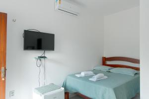 a bedroom with a bed with a flat screen tv at Pousada Águas Claras in Jijoca de Jericoacoara