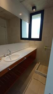 a bathroom with a sink and a mirror and a window at Lucero in Mar Azul +16 photos