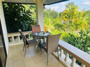 a table and chairs on a porch with a view at House of Garden Resort in Chiang Rai