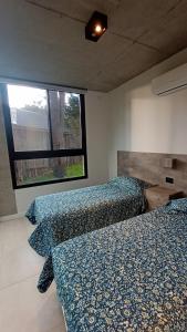a bedroom with two beds and a window at Lucero in Mar Azul