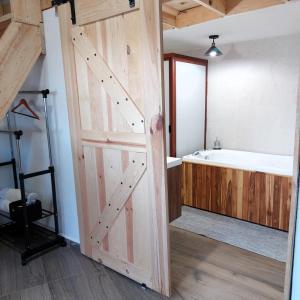 a bathroom with a sliding barn door and a bath tub at Cabañas Big Mountain in Bernal