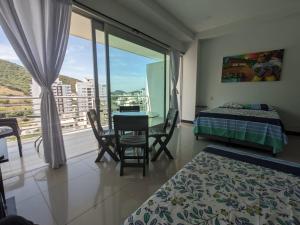 a bedroom with a table and a bed and a balcony at Espectacular Apartamento-Loft, en el Rodadero. in Gaira +31 photos